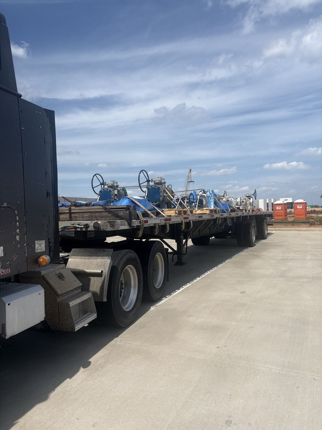 Truck cab pulling a loaded flatbed trailer