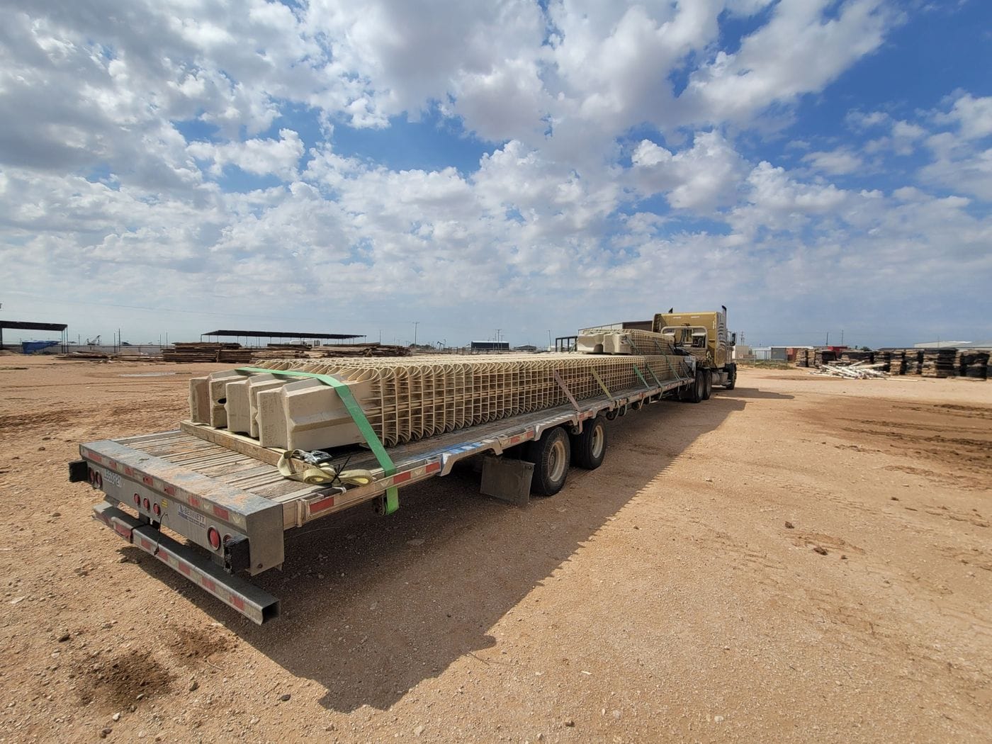Flatbed trailer hauling large pipe sections