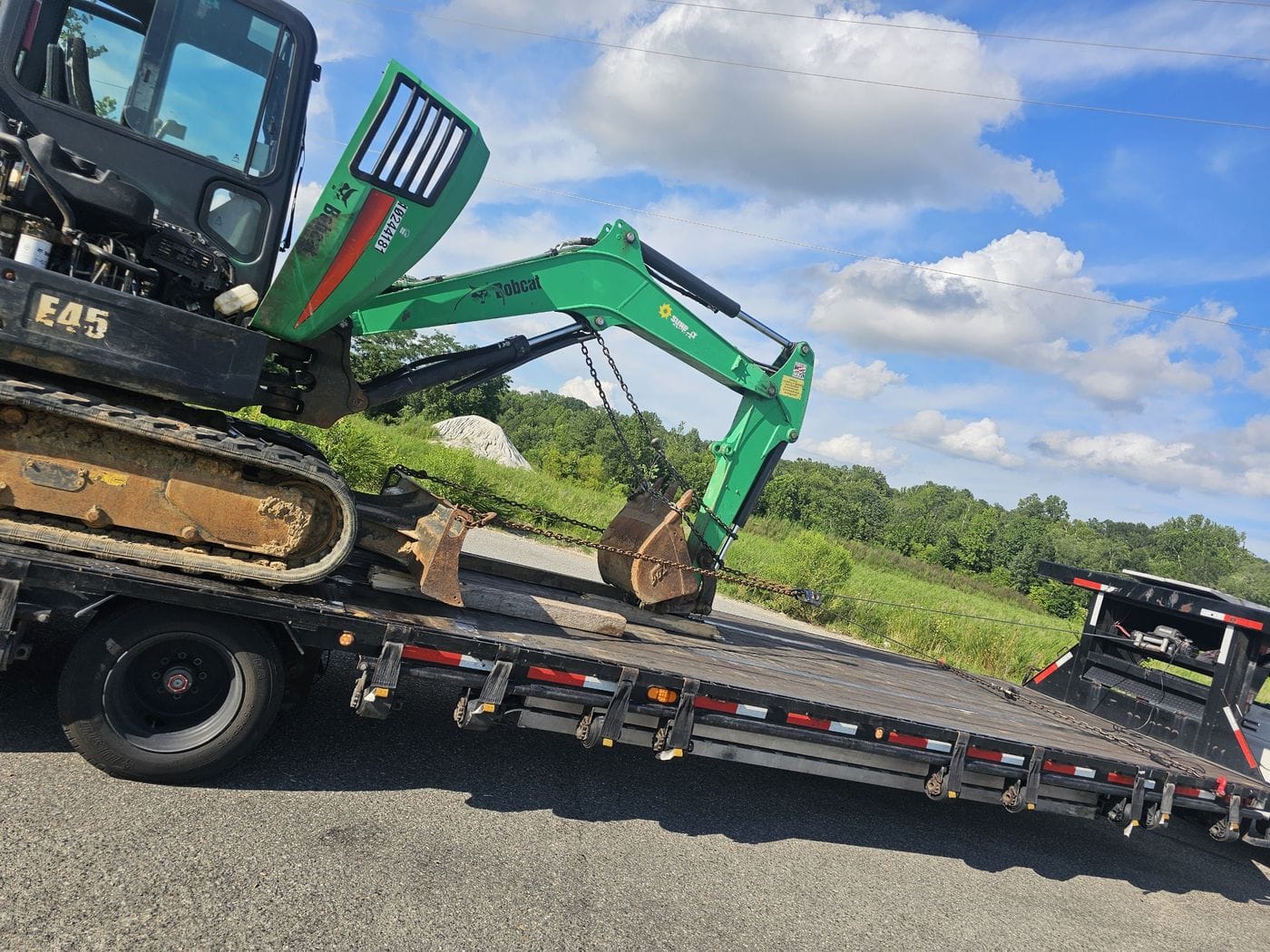 Flatbed trailer hauling an excavator