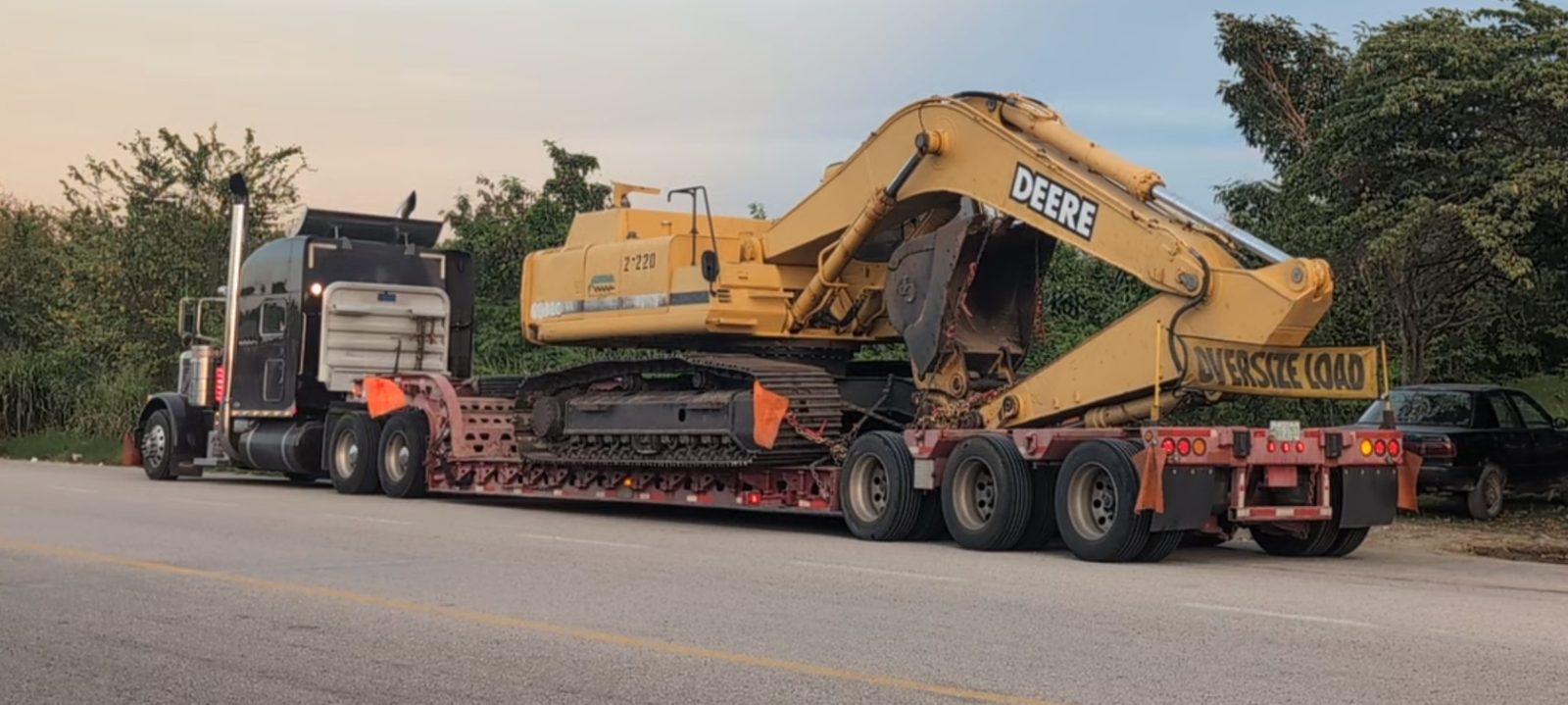Semi-truck hauling an oversize load excavator on a lowboy trailer